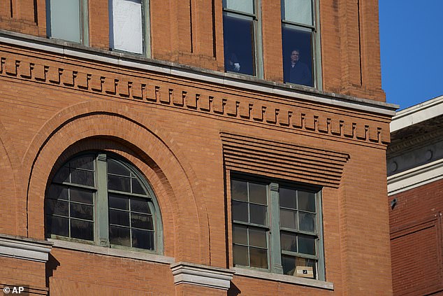 People stand in front of the windows one floor above the 6th floor of the book store