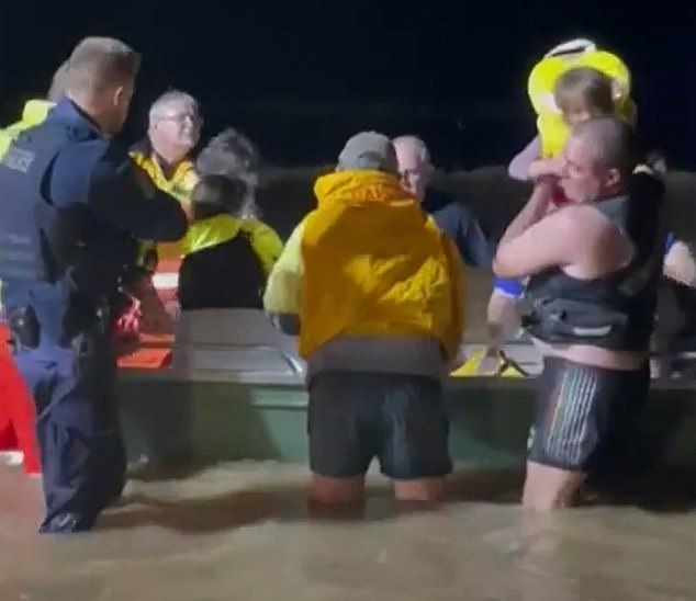 The boy's parents and two younger siblings were rescued by SES workers and taken to Dubbo Hospital (photo: the family being lifted from the lifeboat)