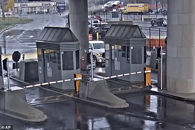 In this image from the security video, a light-colored vehicle, top center, flies over a fence into the Rainbow Bridge customs plaza