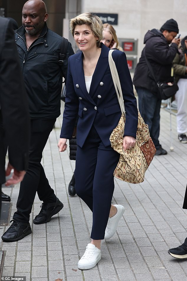 Staying practical: She finished the look with a pair of white sneakers as she showed off her bare ankles in the cropped pants