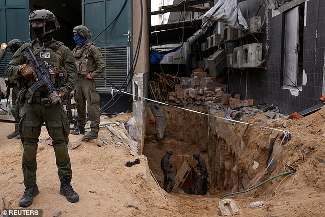 Israeli soldiers stand at the opening of a tunnel on the grounds of Al Shifa Hospital in Gaza City on Wednesday