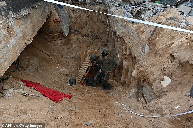 Soldiers stand next to what the Israeli army says is the entrance to a tunnel dug by Hamas militants in the Al-Shifa hospital complex on Wednesday