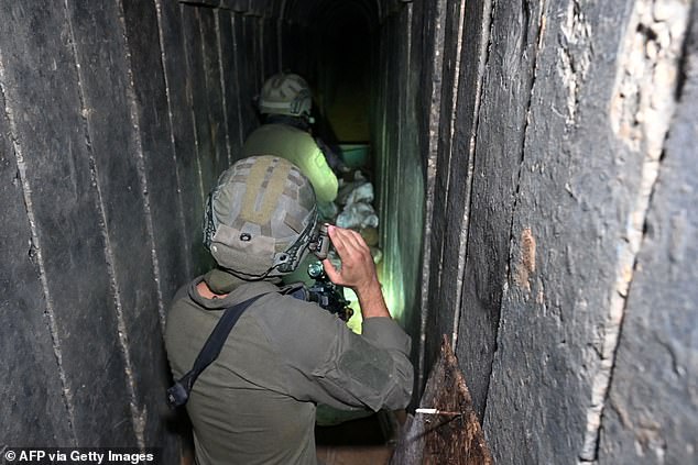 Soldiers walk through what the Israeli army says is a tunnel dug by Hamas militants in the Al-Shifa hospital complex on Wednesday