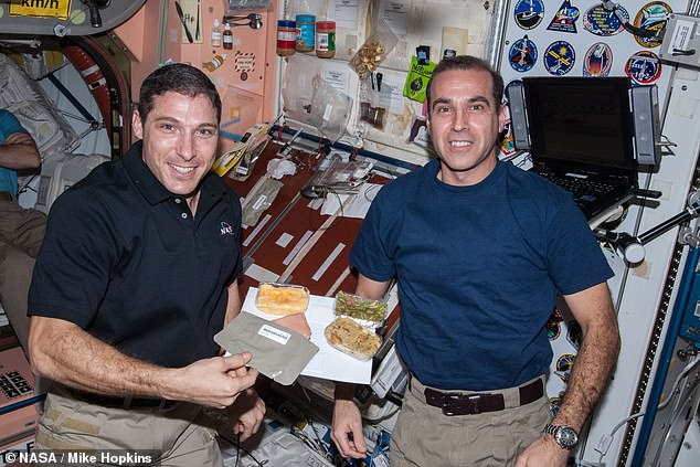 Over the course of 50 years, Thanksgiving dinner on the International Space Station has evolved.  Here Michael Hopkins (left) and Rick Mastracchio (right) show off their 2013 dinner of smoked turkey, green beans, and stuffing.