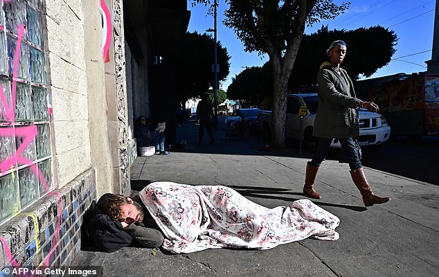 A homeless man sleeps on the sidewalk in Los Angeles.  The cost to build a one-bedroom apartment for the homeless in Los Angeles is $87,000