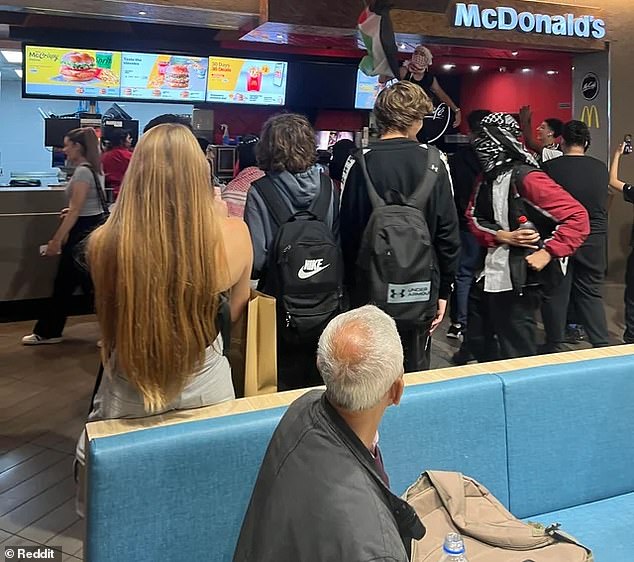 A shocked onlooker claimed a man standing on the McDonald's counter swore at the store manager who asked him to go down