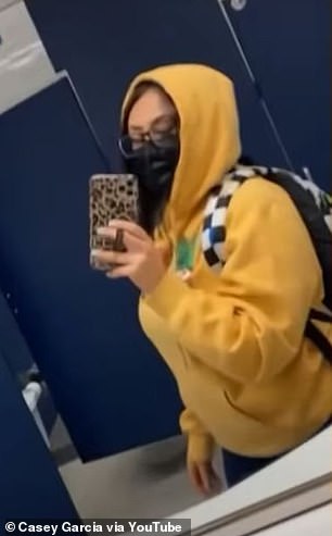 Dressed in a yellow hoodie and plaid backpack, Garcia posed in the school's bathroom mirror