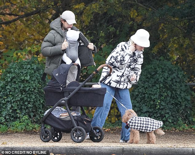 Cozy as a bug in a rug: when it started to rain, the pair wrapped up while Jack zipped up his gray padded jacket, keeping Elsie warm and cozy underneath