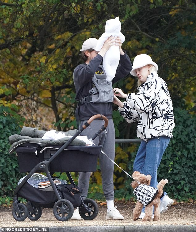 Stylish: the model paired the jacket with jeans and white sneakers, while she completed the look with a white fluffy bucket hat