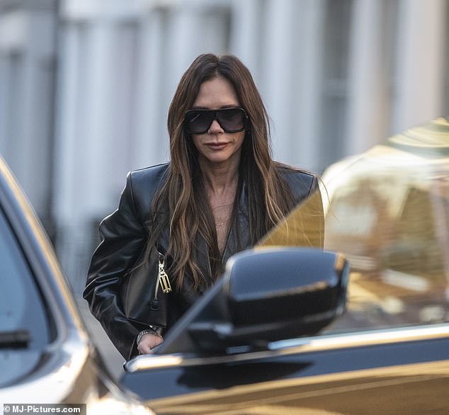 Hang on: Victoria was seen stepping out of the restaurant on her own, while husband David still seemed to be feeling quite hungry