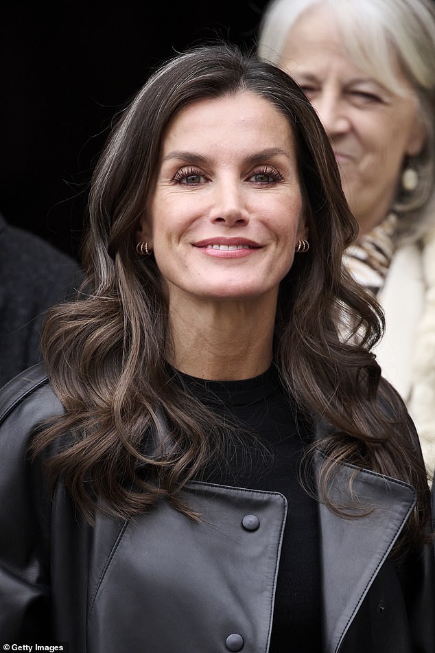 The ever-stylish Letizia wore her chocolate locks down and fell over her shoulders - embracing the gray hairs that were spotted among the brown strands.