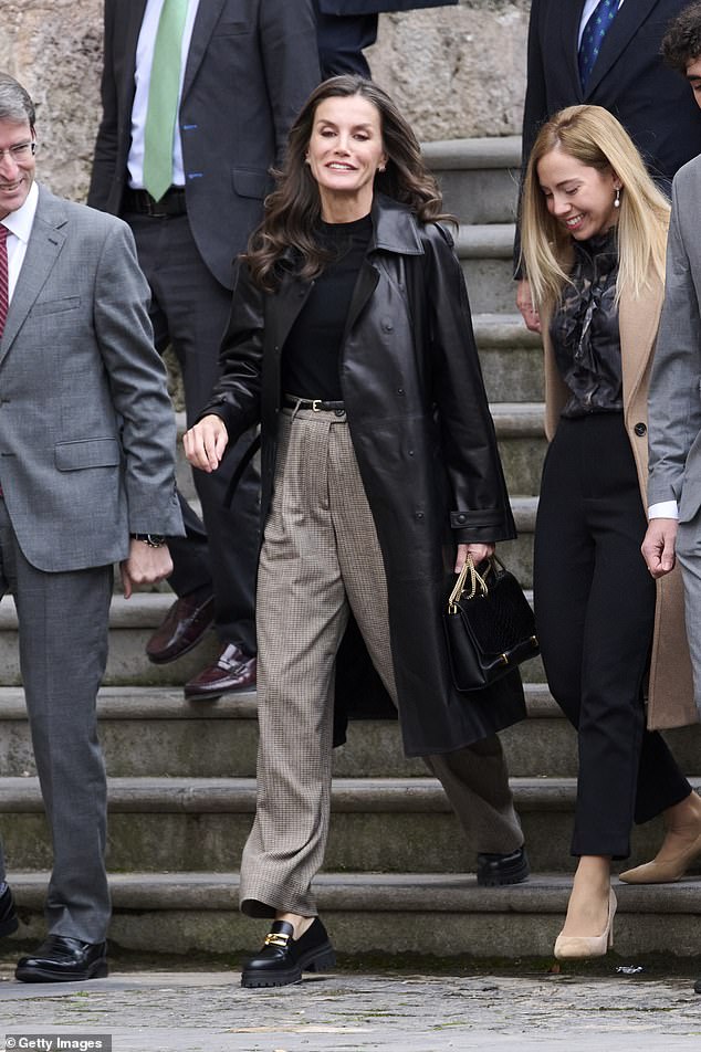 She accessorized her ensemble with triple gold diamond earrings and a black bag with gold straps