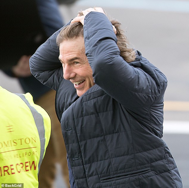 Hold your hair!  He appeared to be struggling to control his longer locks as he battled the strong winds on the helipad