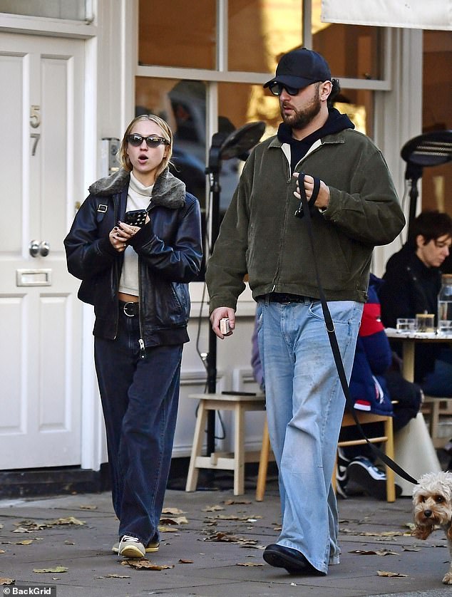 Carefree: The model appeared relaxed and cheerful as she chatted with her friend during the outing in North London