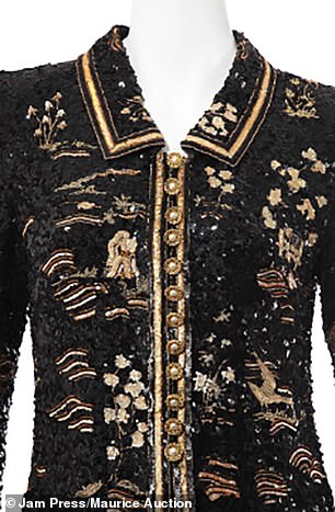 The jacket has striking gold images and round gold buttons and piping