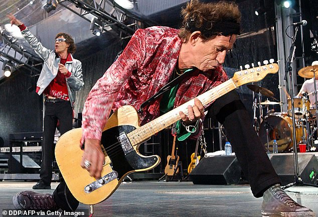 Rolling Stones guitarist Keith Richards rocks the house as singer Mick Jagger belts out a favorite during their concert in Munich, June 6, 2003