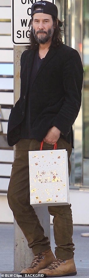 Legging it: Carrying a Christmas-themed bag from the luxury emporium, the Matrix star cut a casual figure as he pounded the pavement in area code 90210