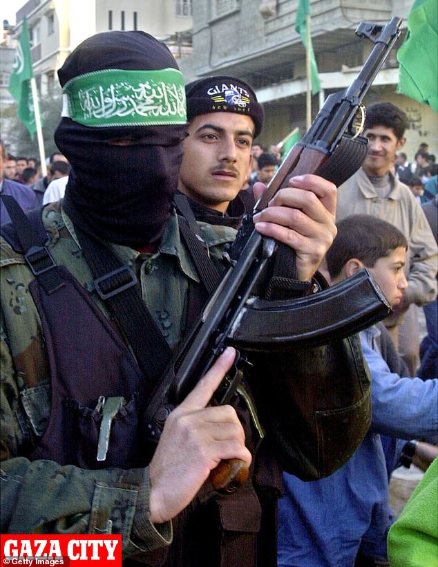 A Hamas terrorist wears the iconic green headband while holding an AK-47 in Gaza City