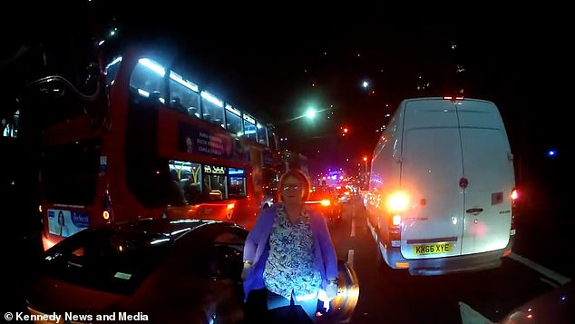 She gets out of the car and accuses the rider of hitting her car - despite him not appearing to make contact with the vehicle