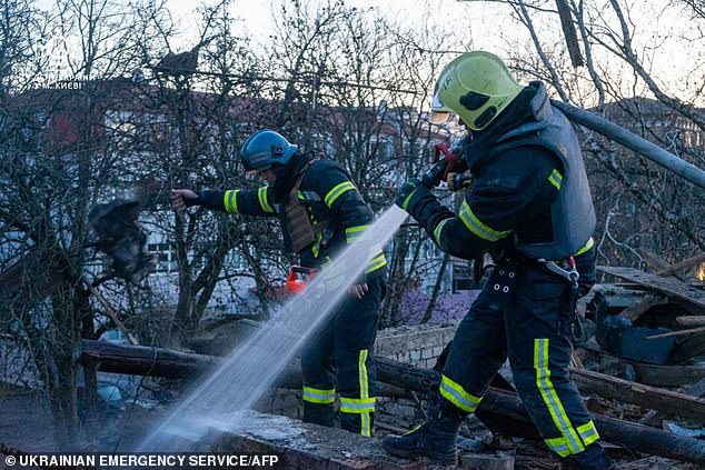 Rescue workers extinguish a fire at the scene of a drone strike.  Ukraine said it had downed most of the 75 Russian attack drones