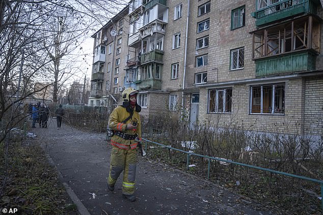 A firefighter examines the damage in an apartment building after the drone attack