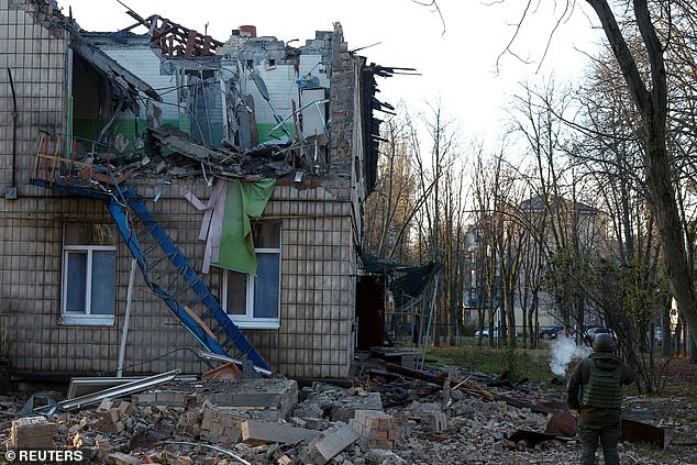 A police officer inspects a kindergarten site damaged by Russian drone strikes