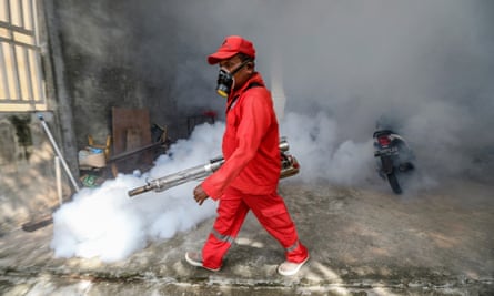 A worker in overalls degasses a room in Indonesia to prevent the spread of dengue fever