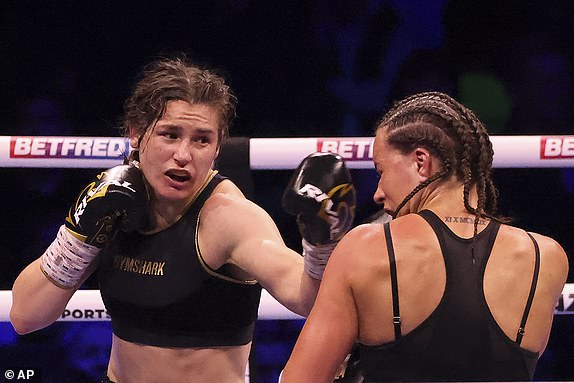 FILE – Ireland's Katie Taylor, left, lands a punch on Britain's Chantelle Cameron during their light welterweight boxing world title fight at the 3Arena in Dublin, Ireland, Saturday, May 20, 2023. Undisputed lightweight champion Katie Taylor questioned whether women's boxing is the "strength and depth" to move on to 3 minute rounds.  The Irish fighter will look to avenge the only loss of her professional career when she faces Chantelle Cameron this month in a rematch of their May fight.  (AP Photo/Peter Morrison, File)