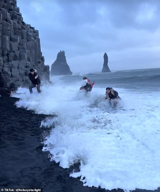 Two of them fell into the water and were swept away by the powerful waves, before managing to get up and walk away