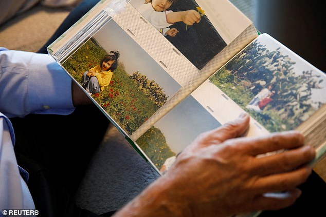 Yakov looks at photos of Noa as a child while thinking about his kidnapped daughter