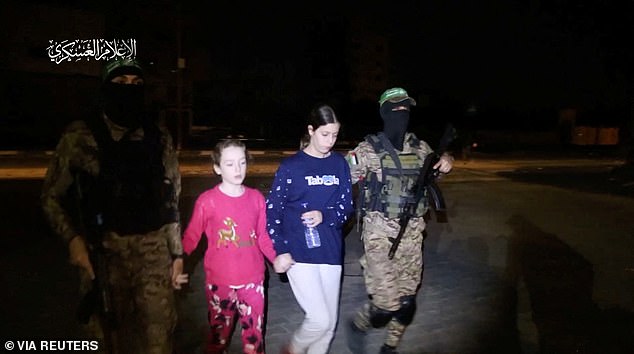 Emily is brought to safety by armed Hamas militants after 50 days in captivity