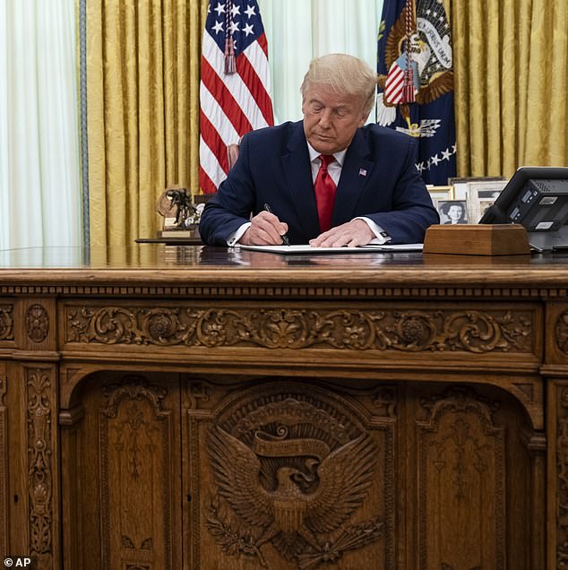 Trump signs a pardon in the Oval Office in August 2020