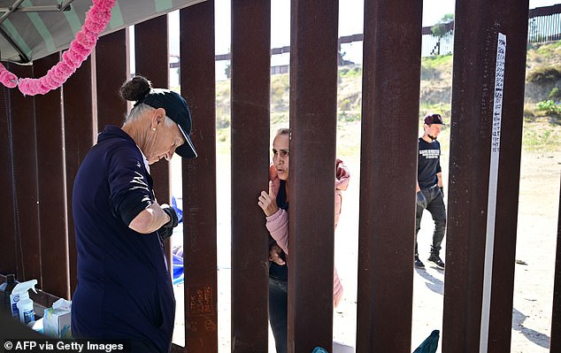 A volunteer is seen distributing supplies to migrants at the US-Mexico border in San Diego, California