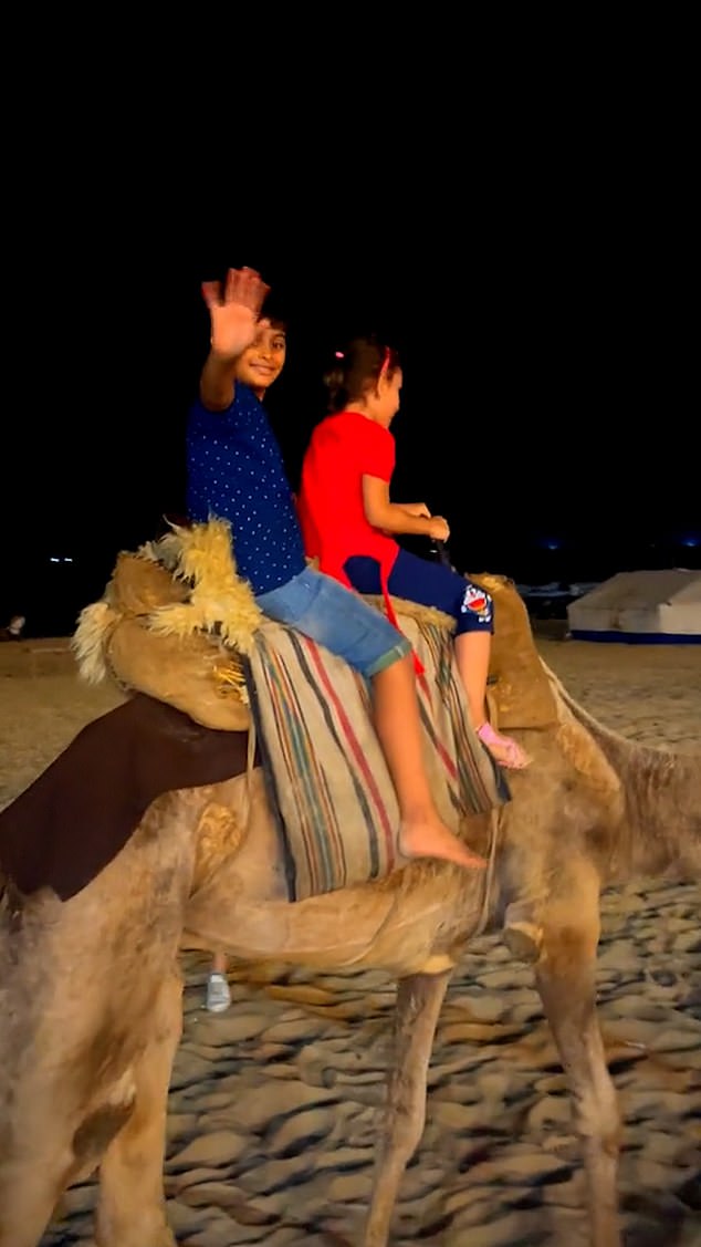 A boy and a girl ride a camel on the beach in Gaza before the October 7 attacks