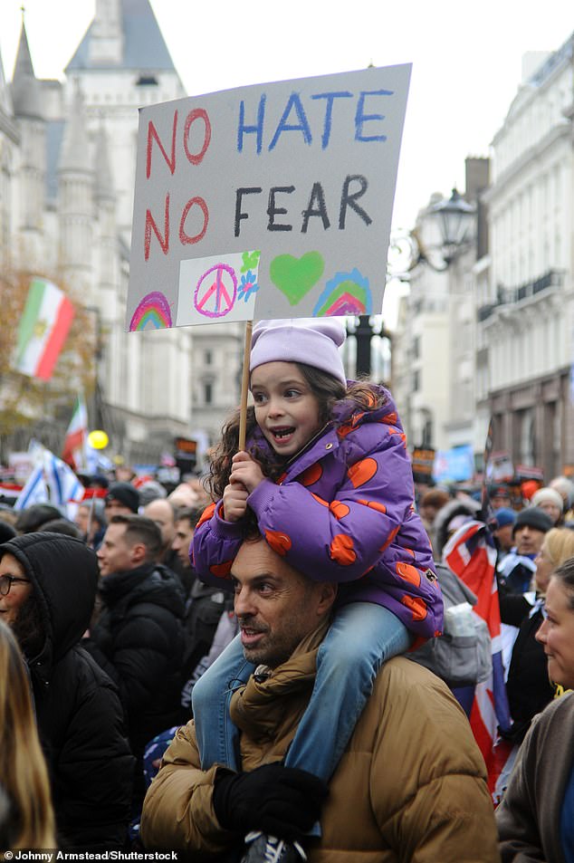 During yesterday's protest, a child is seen holding a banner that reads 'No hate, no fear'