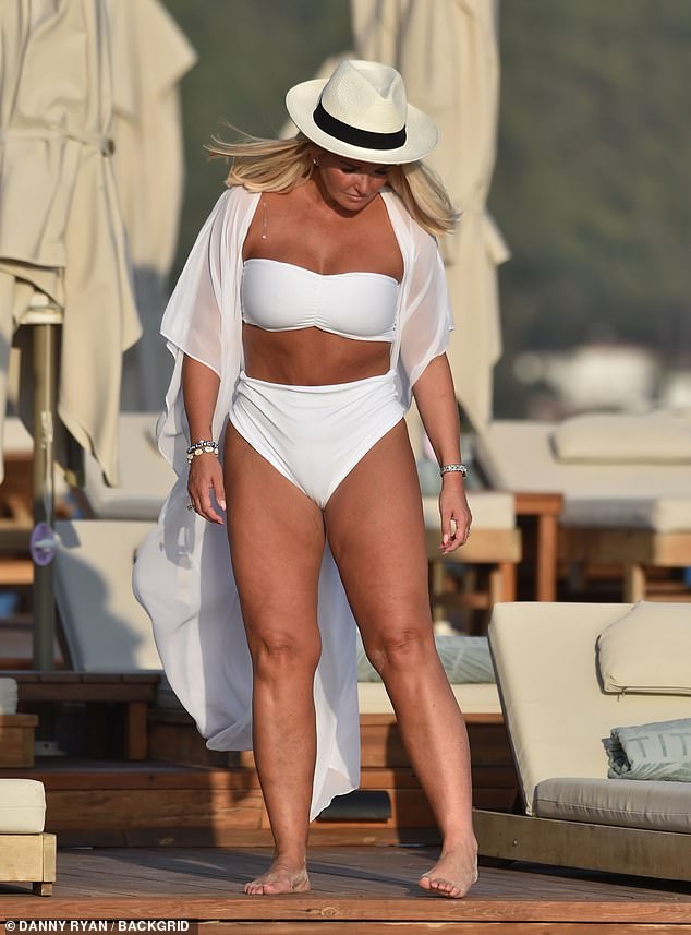 Beautiful: After taking a dip in the water, Jennifer donned a stylish white robe and a white and black hat