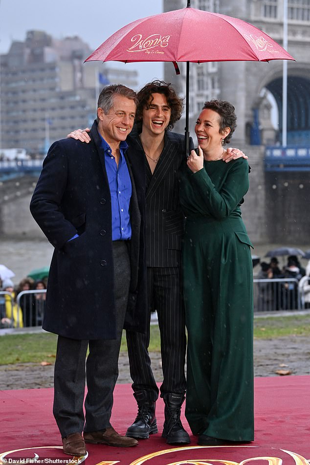 Jovial: Olivia, Hugh and Timothee were in good spirits despite the wet November weather as they attended the photocall