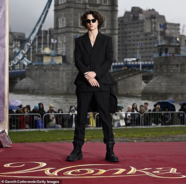 Sharp: Timothee opted for a smart black pantsuit with sparkling silver pinstripes when he attended the photocall