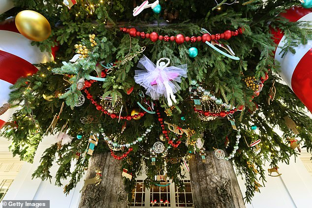 Guests walk into the White House under greenery, ornaments and lighting