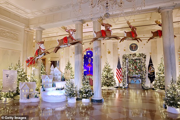 Santa Claus and his sleigh fly through the entrance hall on the state floor