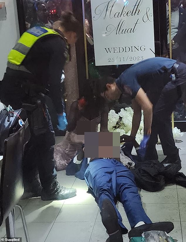 Paramedics are pictured tending to the man after heroic bystanders stabilized him