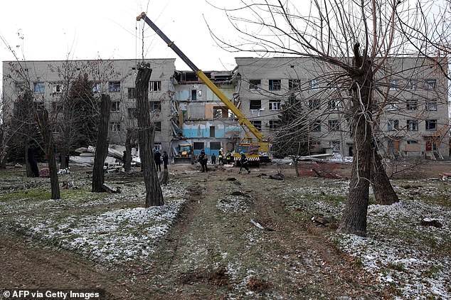 Rescue workers clear debris at a hospital in Selydove, Donetsk region, damaged by a Russian missile attack