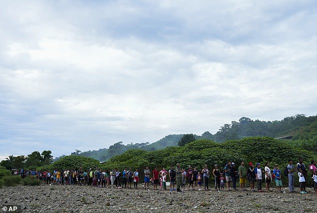 Migrants heading north line up to take a boat in Bajo Chiquito in Panama's Darien Province, Thursday, October 5, 2023, after walking across the Darien Gap from Colombia