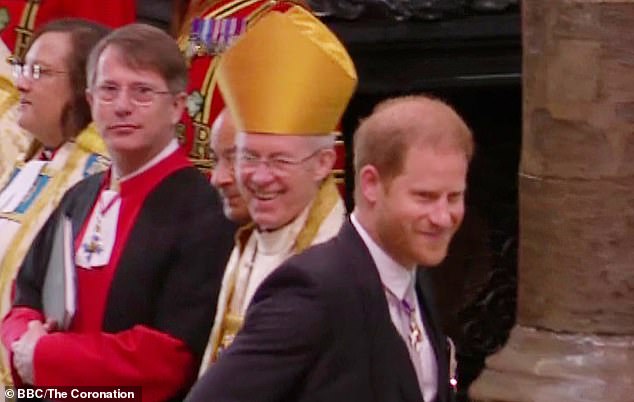 Justin Welby is seen laughing as Harry walks past the abbey with a smile on his face