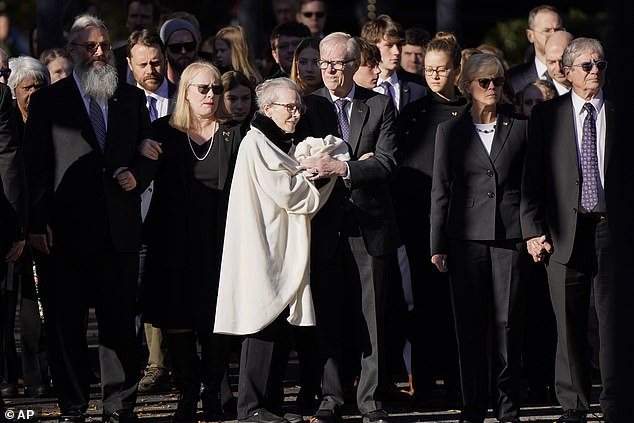 Members of the Carter family gather Monday afternoon in Atlanta, Georgia, as Rosalynn Carter's casket arrived at the Jimmy Carter Presidential Library and Museum.  From left: James Wentzel and wife Amy Carter, Jack Carter, and Becky and James “Chip” Carter