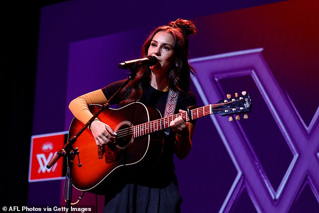 She wore a navy blue skirt and a yellow long-sleeved shirt under a black T-shirt as she took the stage.