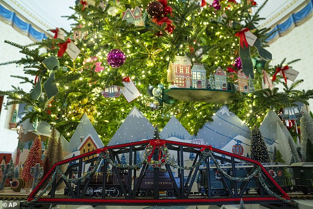 A train runs around the base of the White House Christmas tree