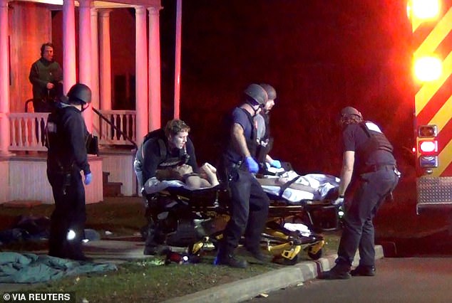 First responders load one of the victims into an ambulance after Saturday's shooting