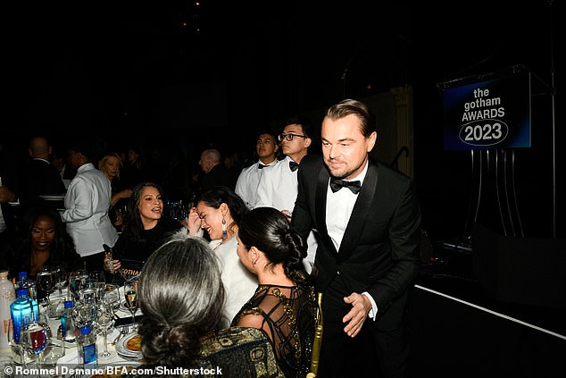 Taking a walk: DiCaprio was pictured chatting with his colleagues as he walked back to his table