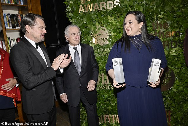 DiCaprio clapped as Gladstone held two trophies before presenting him with one